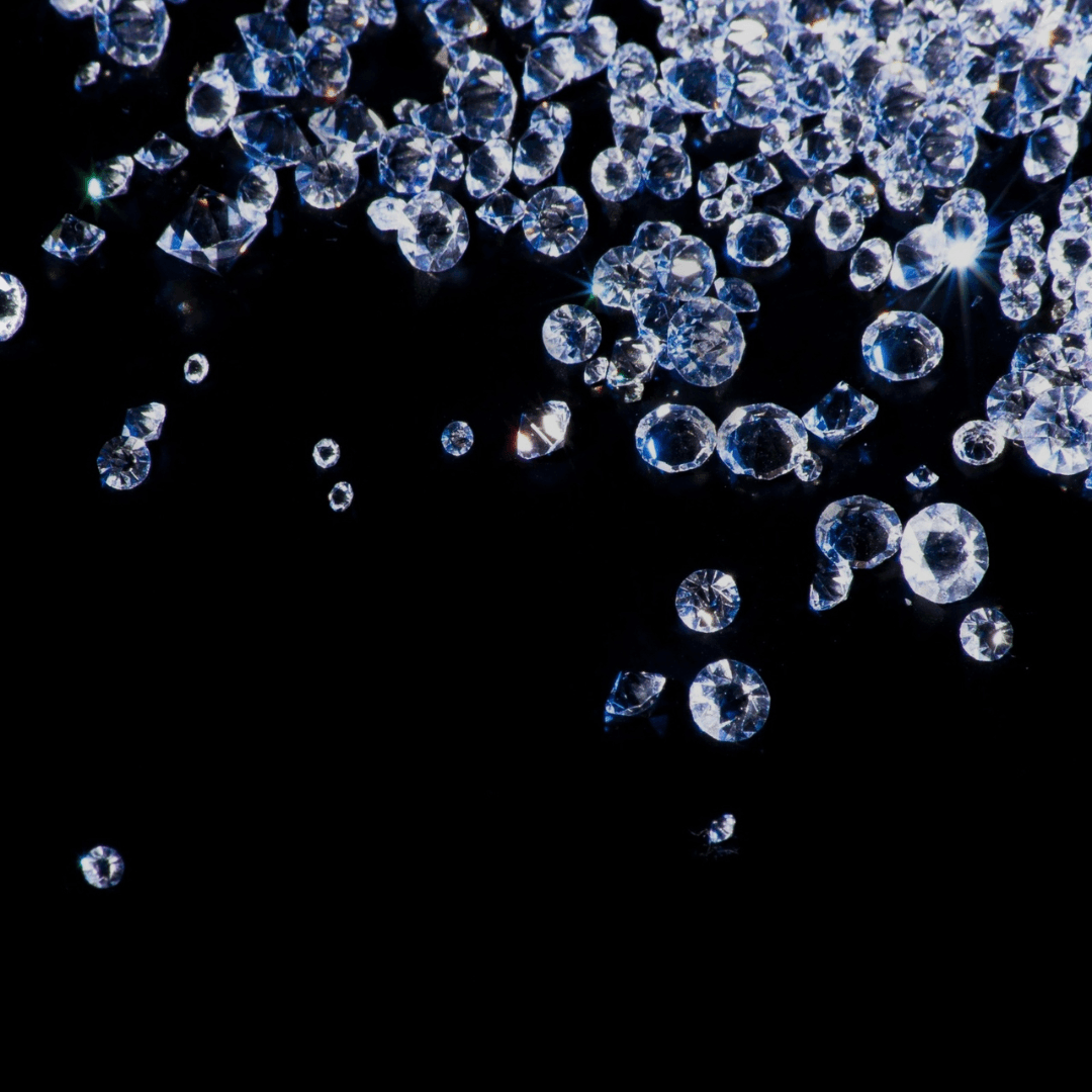 Scattered loose diamonds on a black background